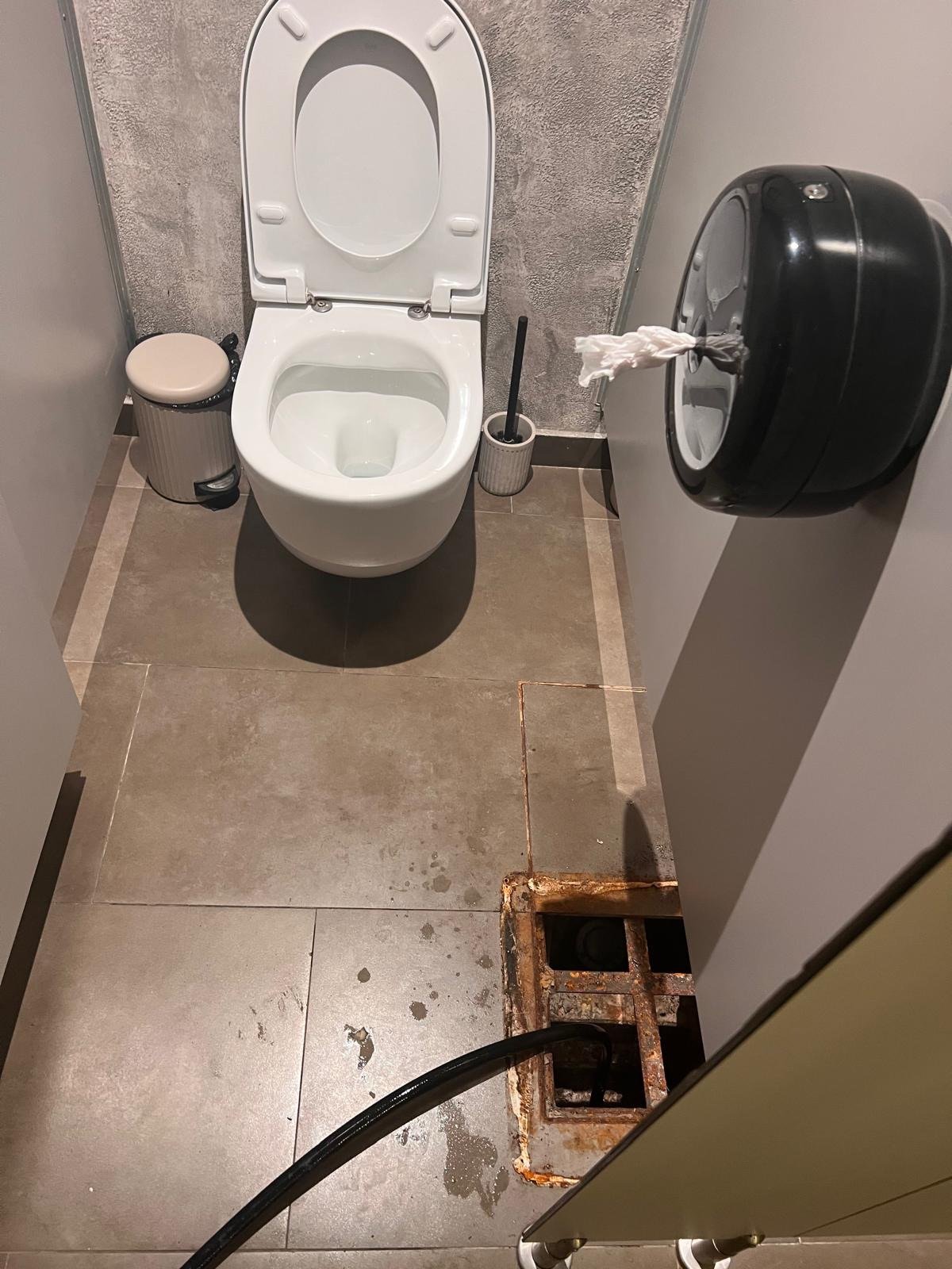 Manguera de limpieza introducida en una arqueta junto a un WC
